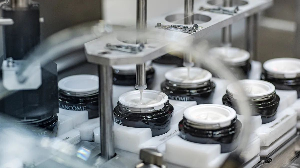 Lancôme jars being filled with white cream on the production line, L'Oréal factory, Le Monde & L'Oréal